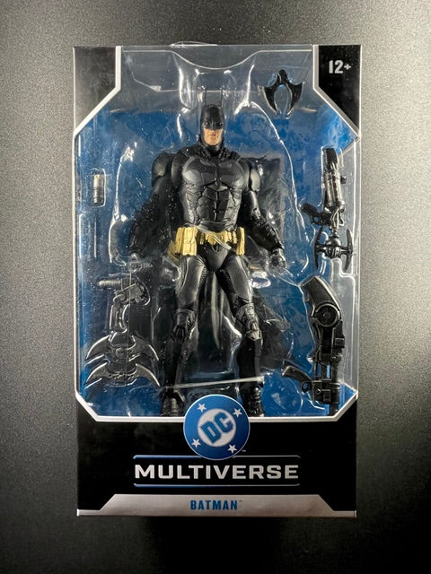 DC Multiverse Batman 7-inch McFarlane Toys action figure wearing black armored Batsuit with gold utility belt and multiple accessories in original box.
