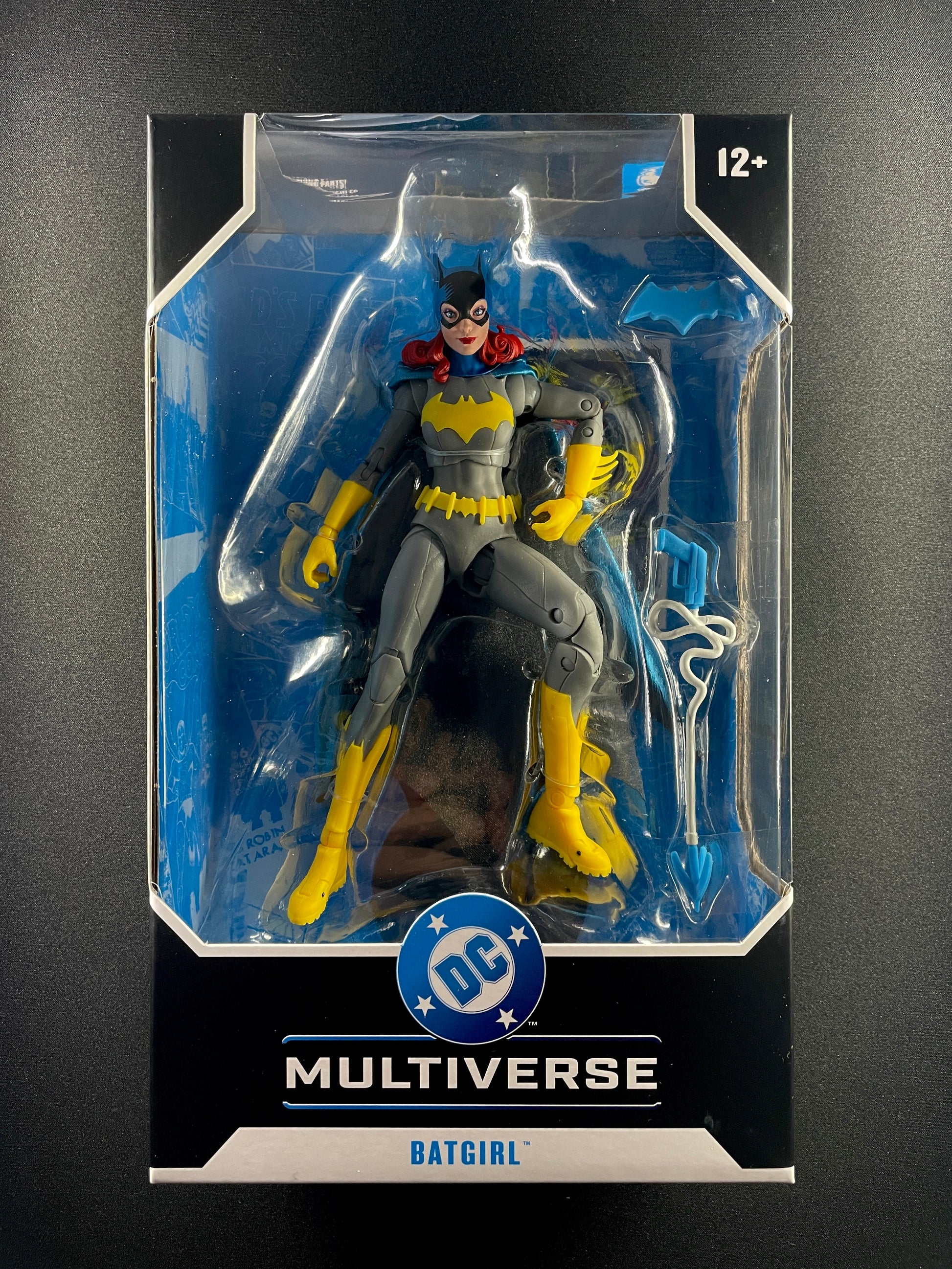 DC Multiverse Batgirl Barbara Gordon 7-inch action figure in grey and yellow suit with grapnel gun accessory.