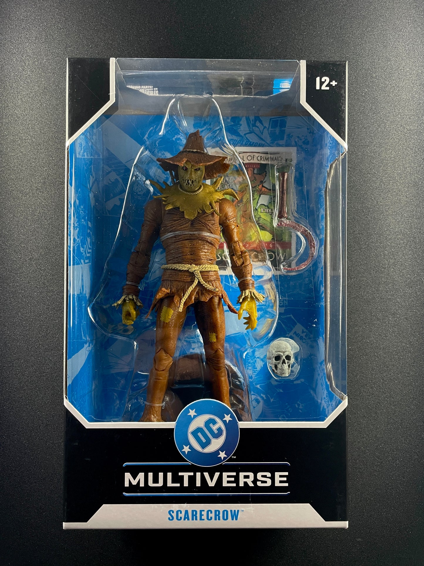 DC Multiverse Scarecrow 7-inch action figure with hook weapon and skull accessory in display box.
