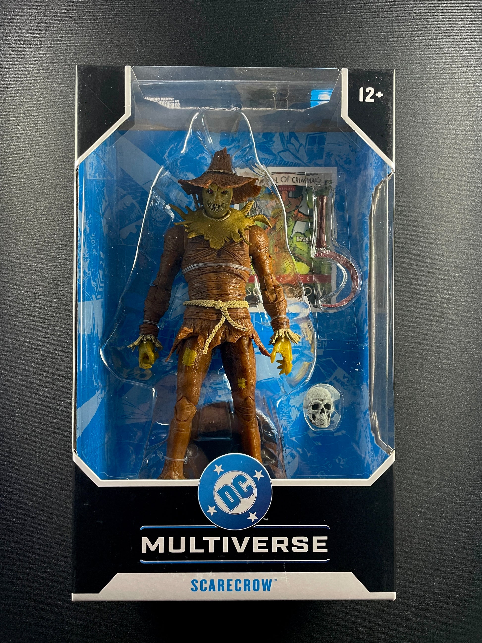 DC Multiverse Scarecrow 7-inch action figure with hook weapon and skull accessory in display box.