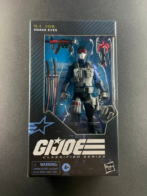 G.I. Joe Classified Series Snake Eyes action figure with tactical armor, red visor, swords, firearms, and Hasbro window box packaging