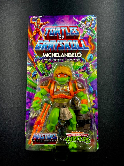 Turtles of Grayskull Michelangelo action figure with orange armor, blond hair, and nunchaku weapons in crossover packaging